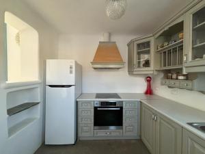 a kitchen with a white refrigerator and a sink at Almyra Yellow Villa in Kithnos