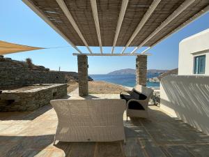 a patio with chairs and a view of the ocean at Almyra Yellow Villa in Kithnos