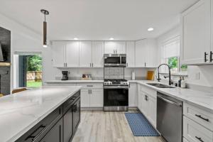 a white kitchen with white cabinets and a sink at Forest Haven in Ashford