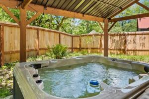 a hot tub in a backyard with a wooden fence at Forest Haven in Ashford