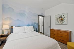 a bedroom with a bed and a mountain mural on the wall at Forest Haven in Ashford