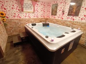 a large bath tub in a bathroom with flowers at Kuća za odmor Janković in Ludbreg