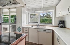 una cucina con un lavello e due finestre di Schmugglerstieg 7 - Dorf 6 a Travemünde Altre 20 foto