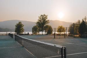 a couple of tennis courts with the sun in the background at Lakefront Studio with Resort Mountain View in Lac-Superieur
