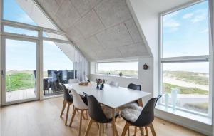 a dining room with a table and chairs and windows at Two-Bedroom Apartment In Thisted in Thisted