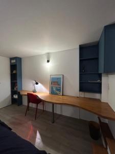 Cette chambre comprend un bureau et une chaise rouge. dans l'établissement Villa Ribot, à Paris 5 autres photos
