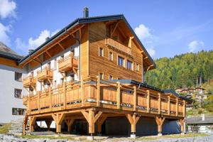 奥瓦伦纳茨Hôtel des Muverans的大型木制房屋,设有大型甲板