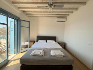a bedroom with a bed with two towels on it at Almyra Red Villa in Kithnos