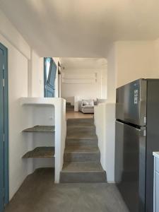 a staircase leading up to a kitchen with a refrigerator at Almyra Red Villa in Kithnos