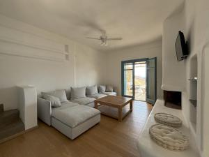 a living room with a couch and a table at Almyra Red Villa in Kithnos