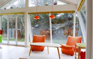 a table and chairs in a room with a window at Villa Mormor in Løkken