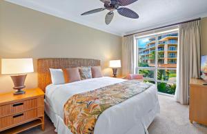 a bedroom with a bed and a large window at Honua Kai Resort And Spa By Maui Resort Rentals in Lahaina