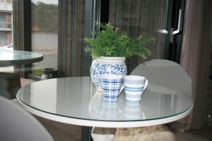 un vaso blu e bianco con una pianta su un tavolo di vetro di Ny leilighet med fantastisk sjøutsikt i Fredrikstad a Kråkerøy
