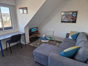 a living room with a couch and a tv at Glaz - appart-sympa - T1 bis en plein centre de Plœmeur in Ploemeur