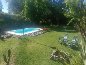 a yard with a swimming pool and two chairs at Casa Darragueira de Chacras de Coria in Chacras de Coria +37 photos