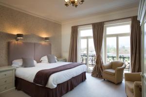 a hotel room with a bed and a balcony at The Bell Hotel in Sandwich