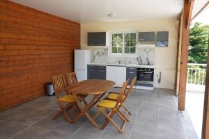 una cucina con tavolo e sedie in legno di Carbet,bord de mer a Le Carbet
