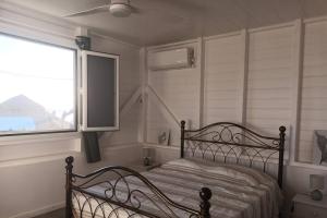 une chambre avec un lit et une grande fenêtre dans l'établissement Carbet,bord de mer, à Le Carbet