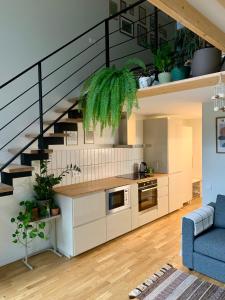 a living room with a kitchen and a staircase at Vilnius Cozy Loft in Vilnius