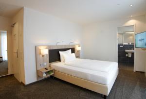 een slaapkamer met een groot wit bed en een badkamer bij Hotel Go2Bed Weil am Rhein - Basel in Weil am Rhein +23 foto's
