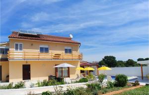 una casa gialla con due ombrelloni e sedie gialli di 3 Bedroom Beautiful Home In Muntic a Muntić Altre 29 foto