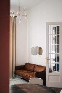 a living room with a brown couch and a table at Apartament Studio Migot in Przemyśl
