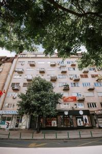 a large building with a tree in front of it at 4U Apartment in Skopje
