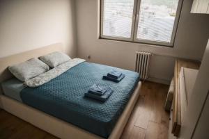 a bedroom with a bed with two shoes on it at 4U Apartment in Skopje