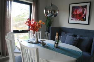 tavolo da pranzo con divano blu e tavolo e sedie bianchi di Ny leilighet med fantastisk sjøutsikt i Fredrikstad a Kråkerøy