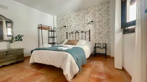 a bedroom with a bed and a floral wall at Alojamiento Fuente Alta in Cazorla