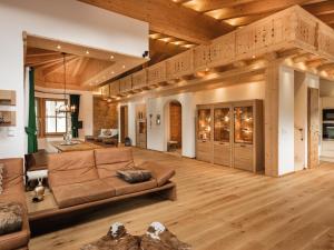 ein großes Wohnzimmer mit einem Sofa und Holzböden in der Unterkunft Chalet Märchenblick in Leutasch