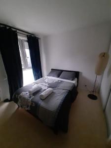 a bedroom with a bed in a room with a window at Logement T2 tres propre in Cergy