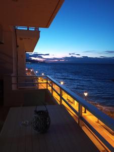a balcony with a view of the ocean at night at SKY AND SEA APARTMENT in Xylokastro +17 photos