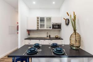 a kitchen with a table with plates and wine glasses at Bright apartment with garden in Porto