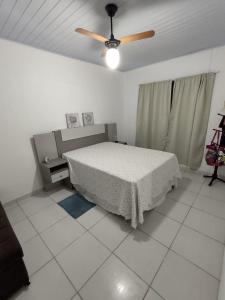 インベーにあるCasa de Praiaのベッドと天井扇風機のある寝室 +6枚の写真
