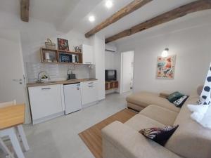a large living room with a couch and a kitchen at KukoriQ 2 Apartman in Siklós