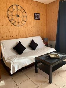 una camera da letto con un letto con un orologio sul muro di Gîte Cottage 2 à 4 pers Bulle Der 12B Lac du der a Giffaumont