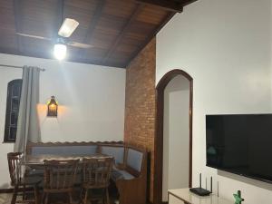 a dining room with a table with chairs and a television at Casa toda Equipada 900 metros da Lagoa, próxima as praias in São Pedro da Aldeia