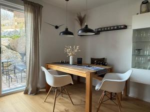 a dining room with a wooden table and white chairs at Ferienwohnung Gschwendt in Miesbach