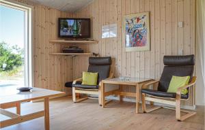 a room with two chairs and a table and a tv at Holiday Home Ringkobing Xliv in Klegod