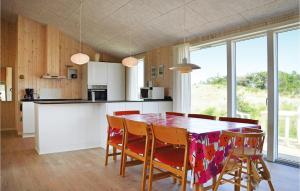 a kitchen and dining room with a table and chairs at Holiday Home Ringkobing Xliv in Klegod