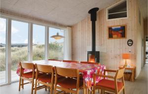 a dining room with a table with chairs and a fireplace at Holiday Home Ringkobing Xliv in Klegod +18 photos