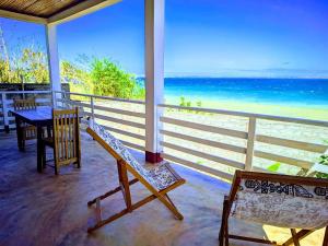 a porch with a bench and a table and the ocean at Maison en bord de mer in Diego Suarez +15 photos