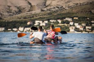 a group of three people riding on a boat in the water at Hotel Plaza in Pag