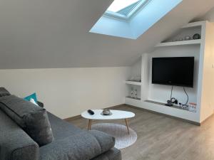 a living room with a couch and a flat screen tv at Villa Bellevue in Saint-Louis