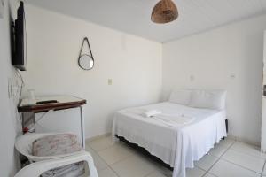 um quarto branco com uma cama e uma mesa em Villa Di Loire no Balneário Camboriú mais 24 fotografias