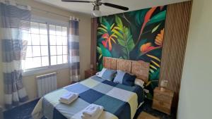 een slaapkamer met een bed met een schilderij aan de muur bij Bianca Seaview & Beach Apartment in Montgat