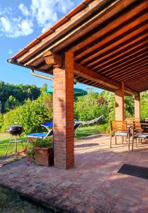 a pavilion with a grill and a table and chairs at Casa Gioia in Laterina