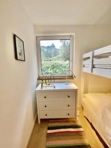 a small bedroom with a dresser and a window at Ferienbungalow Arne am Wald in Woltersdorf