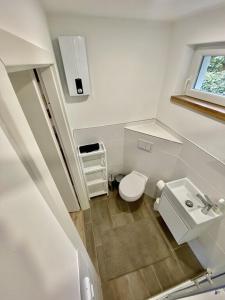 a small bathroom with a toilet and a sink at Ferienbungalow Arne am Wald in Woltersdorf